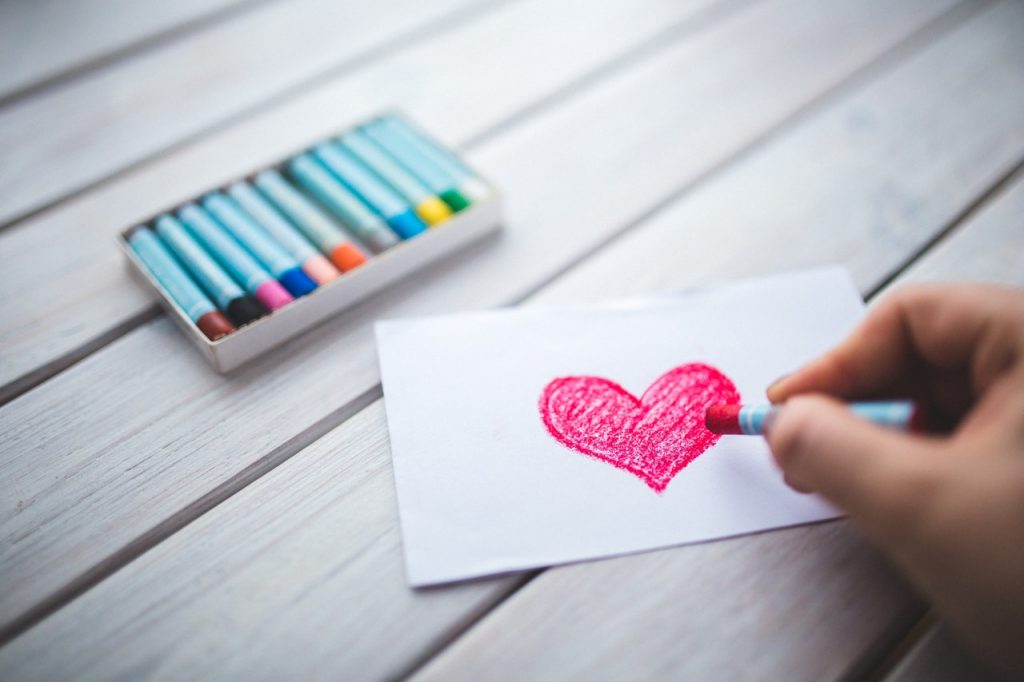 person coloring a heart